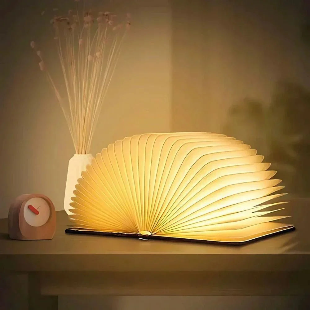 Faltbare Buchlampe aus Holz und Papier mit warmem Licht
