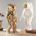 Golden and white astronauten-figur decorative pieces with plant compartment functionality