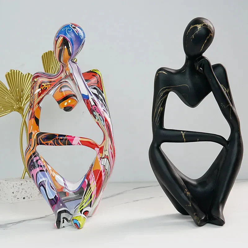 Two Abstrakte Denker Skulptur pieces, colorful graffiti and black marble finishes