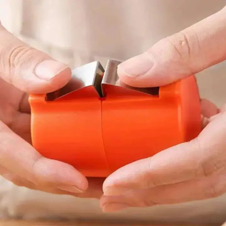 Close-up of orange 2in1 Eieröffner Eigelbtrenner egg opener held in hands