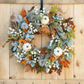 Autumn wreath with maple leaves and pumpkins for the front door