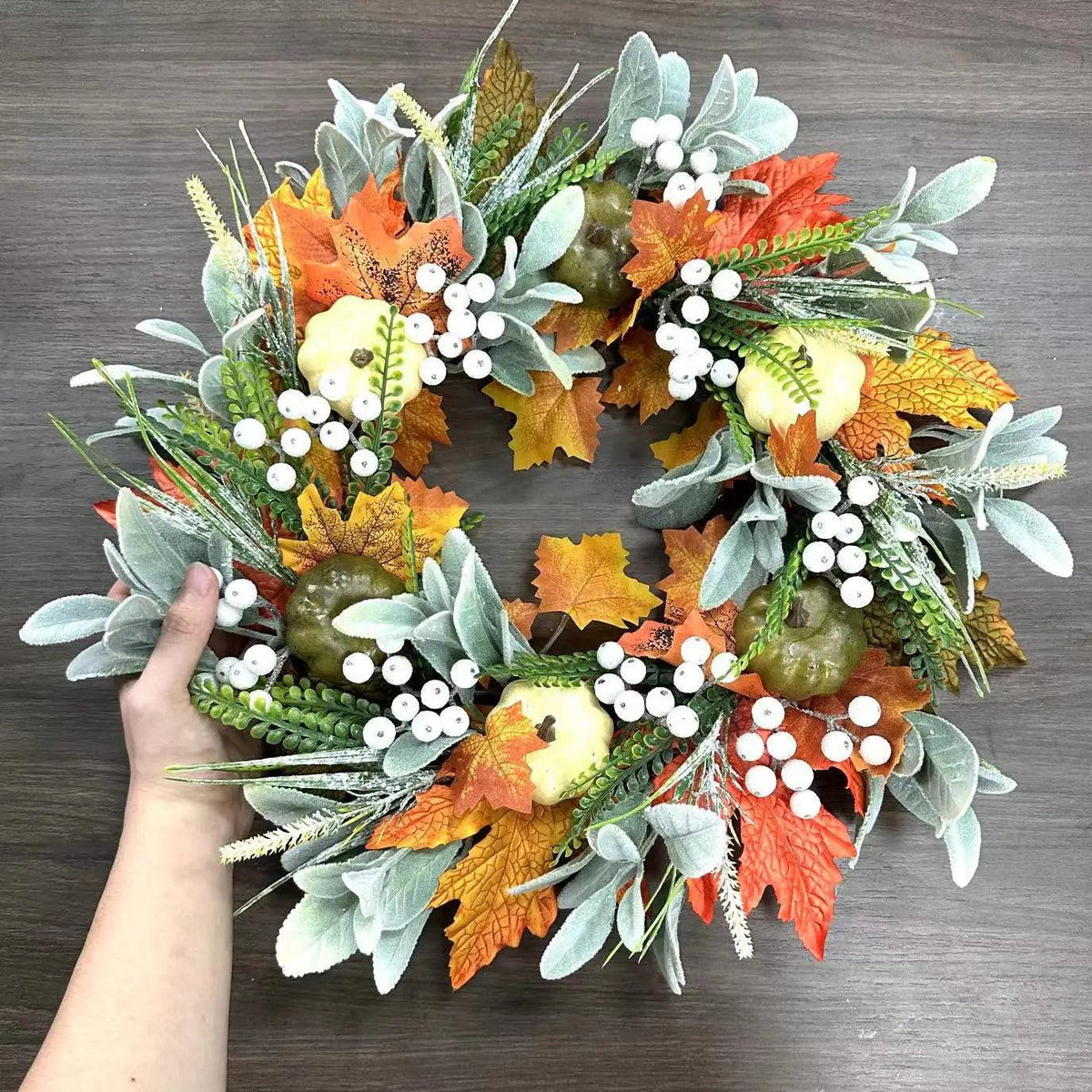 Herbstkranz mit Ahornblättern und Kürbissen für die Haustür